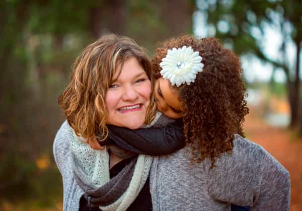 Heidi Dunbar and a girl wrapped around her shoulder